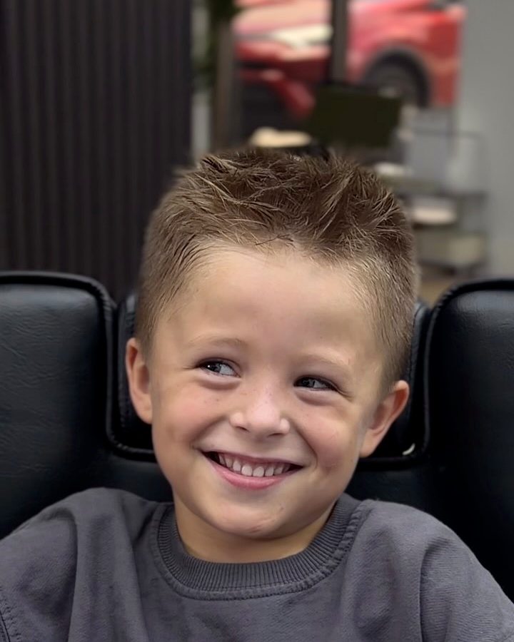 Young client grinning at the camera with his fresh haircut